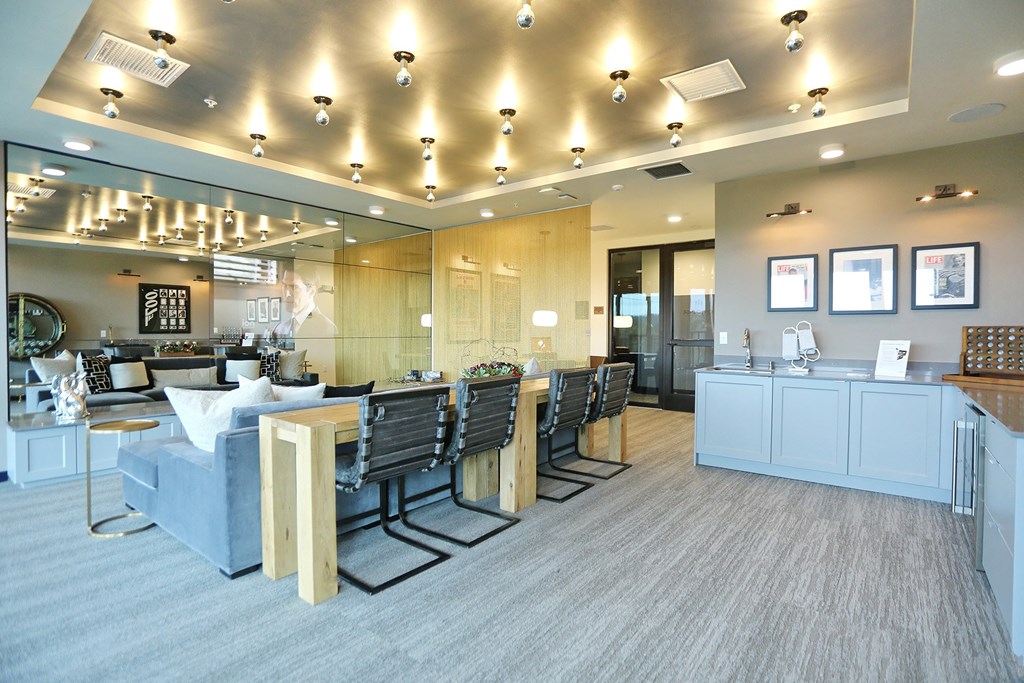 a reception area with a couch and chairs and a counter with a sink