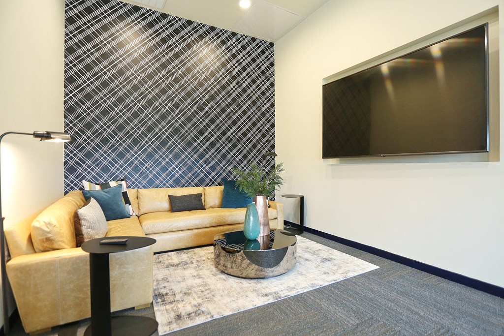 a living room with a yellow couch and a tv on the wall