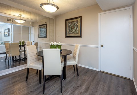 A dining room with a table and chairs.