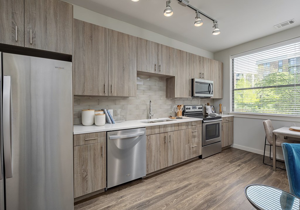 A modern kitchen with wooden cabinets and stainless steel appliances.
