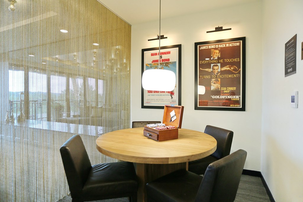 a table and chairs in an office with posters on the wall