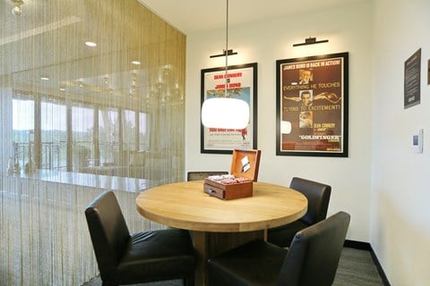 a table and chairs in an office with posters on the wall