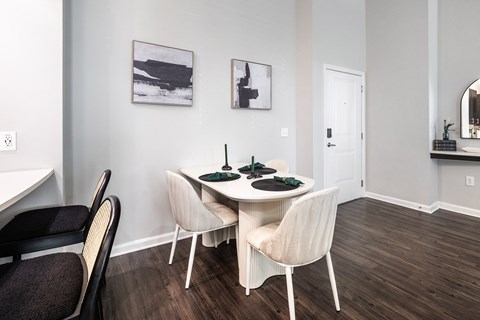 A dining room with a white table and chairs.