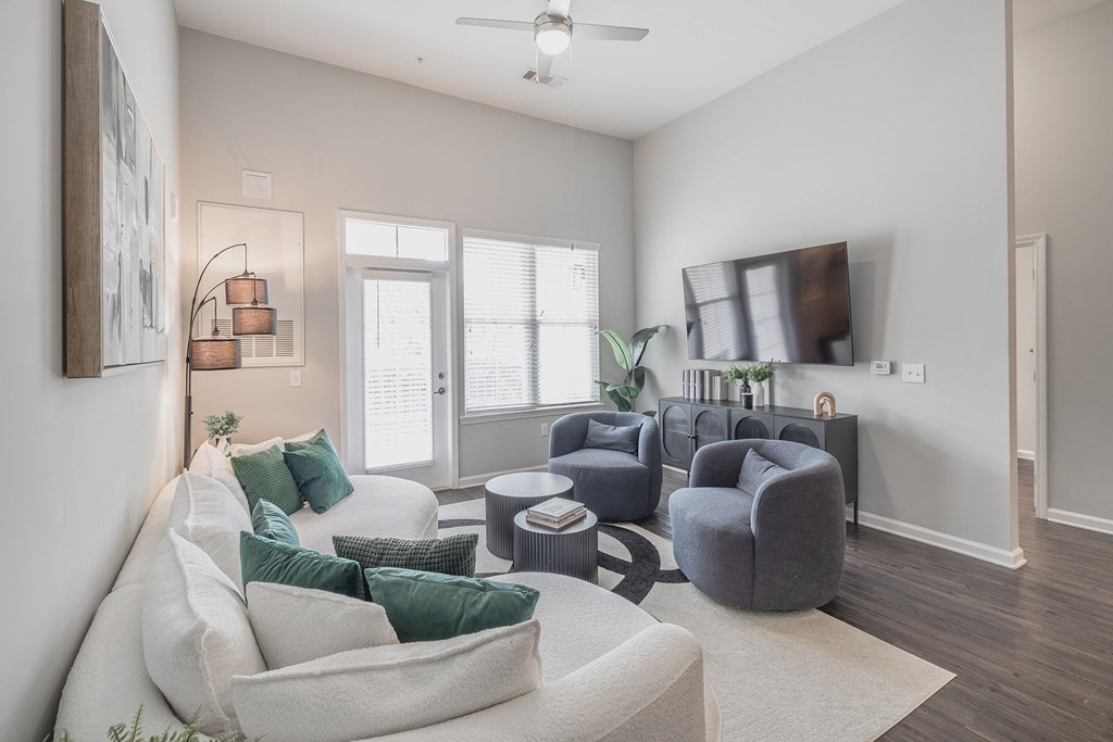 A living room with a white couch and a grey armchair.