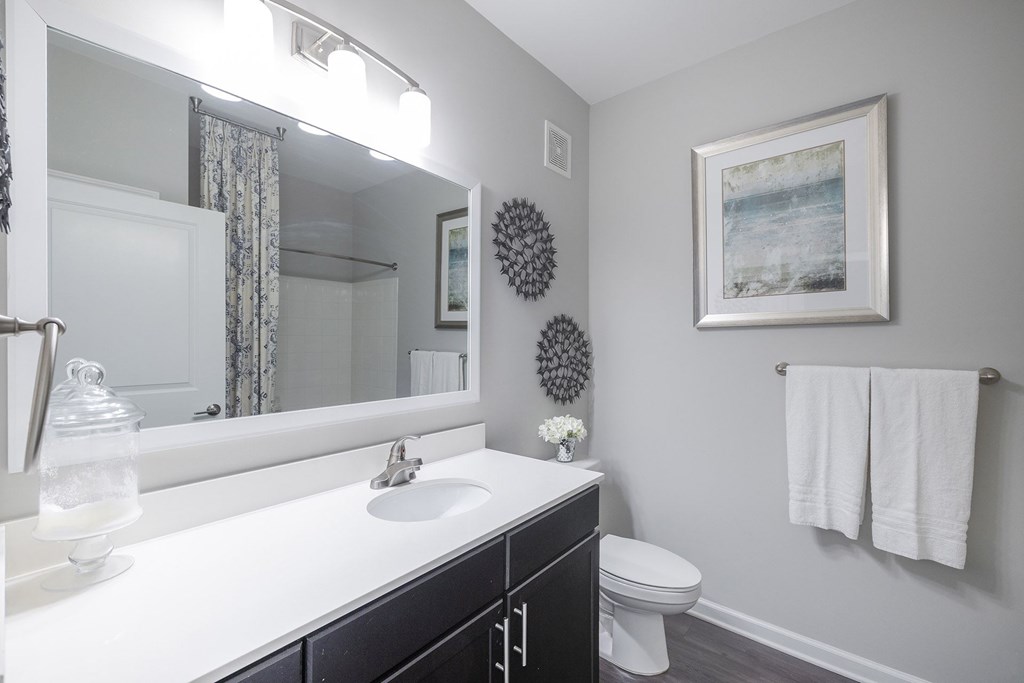 A bathroom with a white sink and a white toilet.