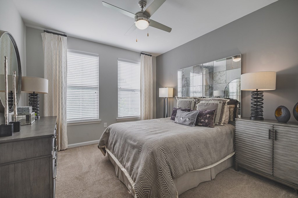 A bedroom with a bed, dresser, and mirror.