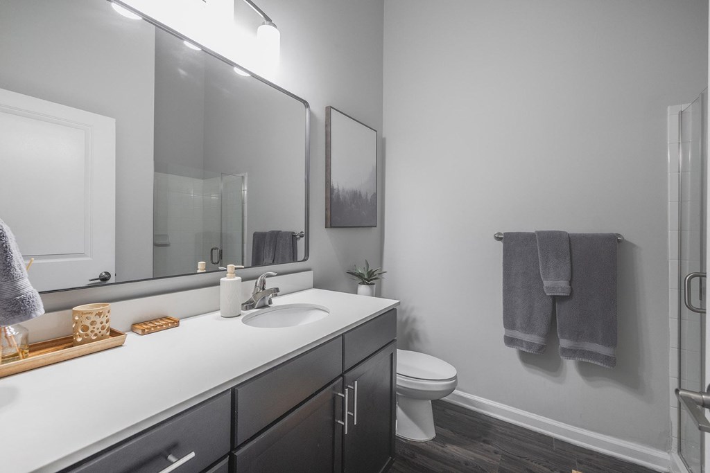 A bathroom with a white sink and a white toilet.