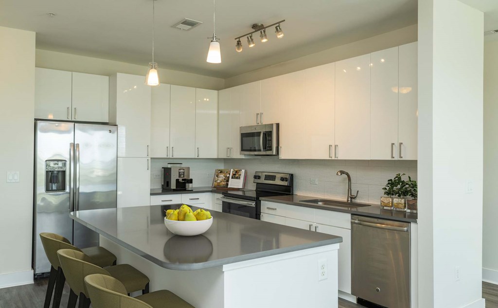 A modern kitchen with a bowl of fruit on the island.