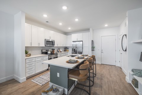 A kitchen with a table and chairs in the middle of it.