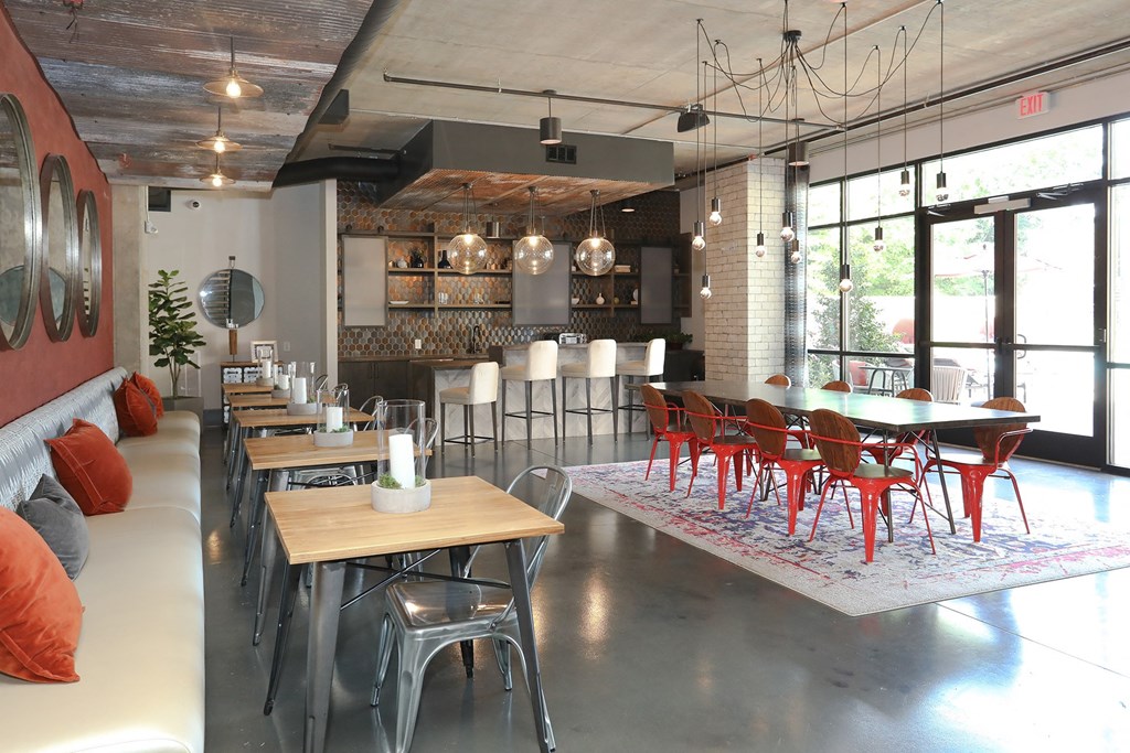 a dining room with tables and chairs and a kitchen in a loft