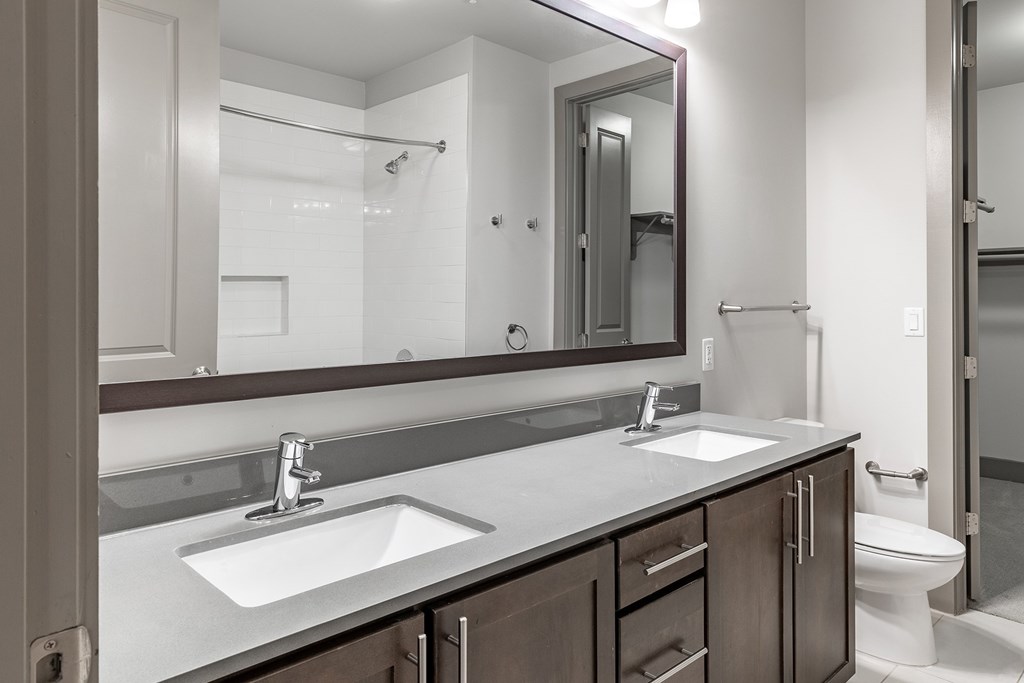 A bathroom with a sink, mirror, and toilet.