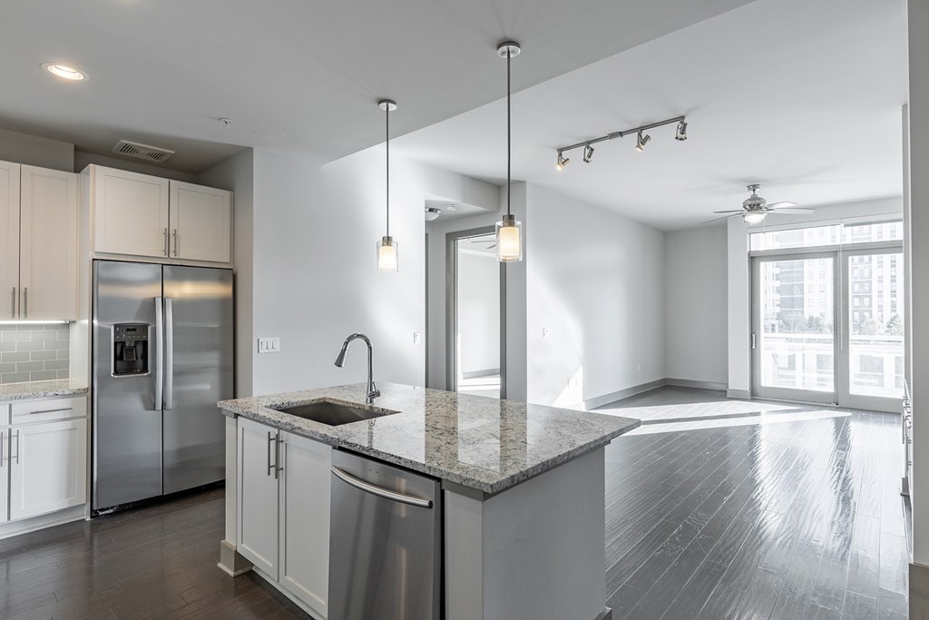 A modern kitchen with stainless steel appliances and a marble countertop.