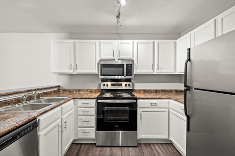 a kitchen with stainless steel appliances and white cabinets