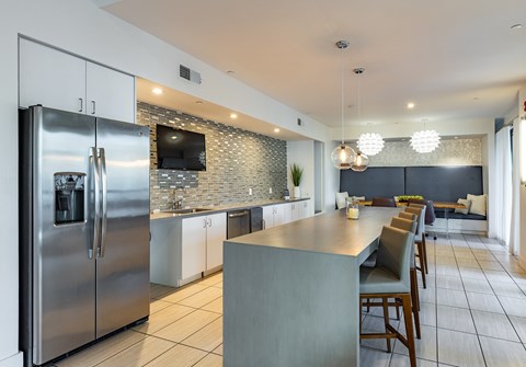 a kitchen with stainless steel appliances and a long island with chairs
