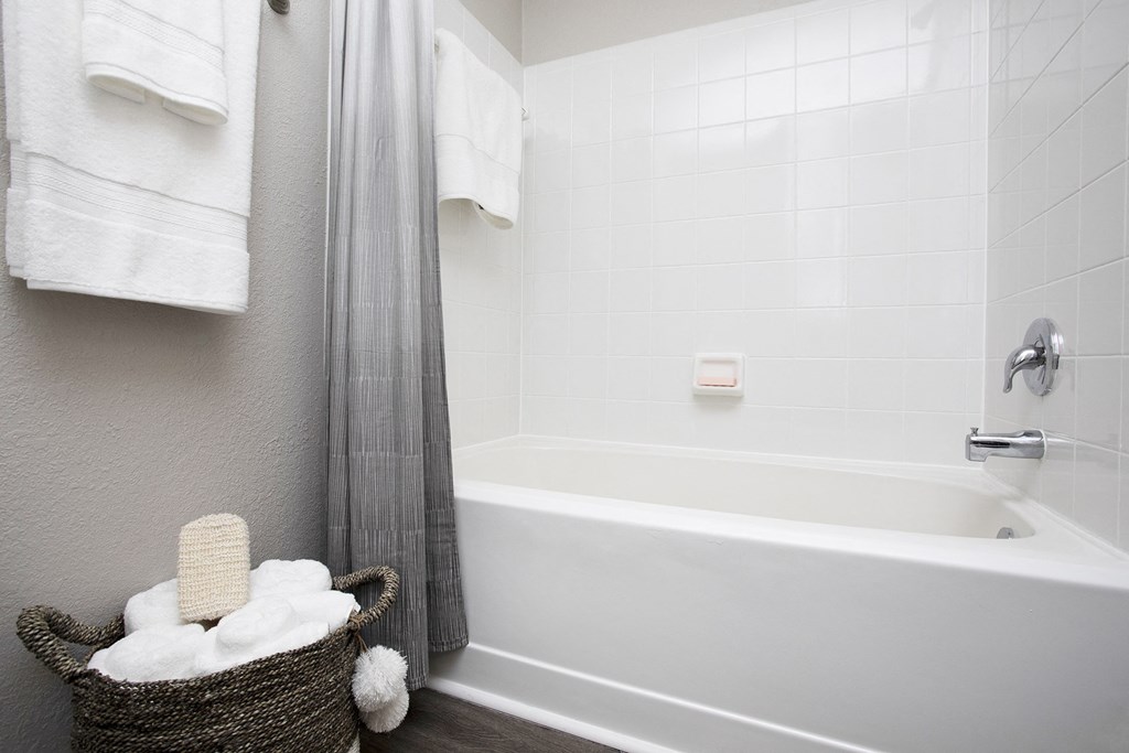 a bathroom with a bathtub and a basket of towels at Thornblade, Greenville, South Carolina