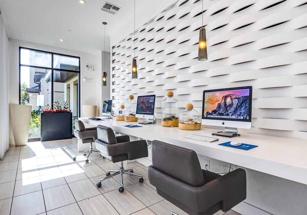 Luxury Apartments for Rent in Altamonte Springs, FL - Nine12 Gateway - Wifi Cafe with Spacious Workstations, Desktop Computers, Leather Office Chairs, Pendant Lights, and Large Floor-to-Ceiling Window.