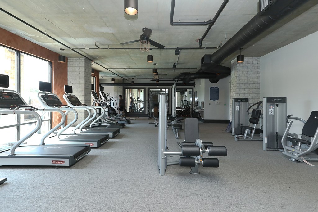 a gym with cardio equipment and weights in a building