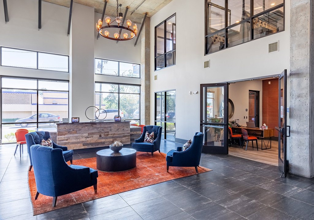 a large lobby with blue chairs and a reception desk