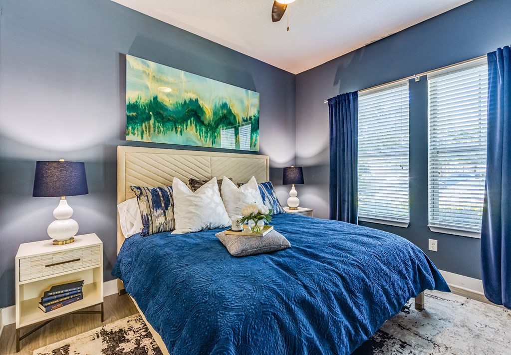 a bedroom with blue walls and a blue and white bed