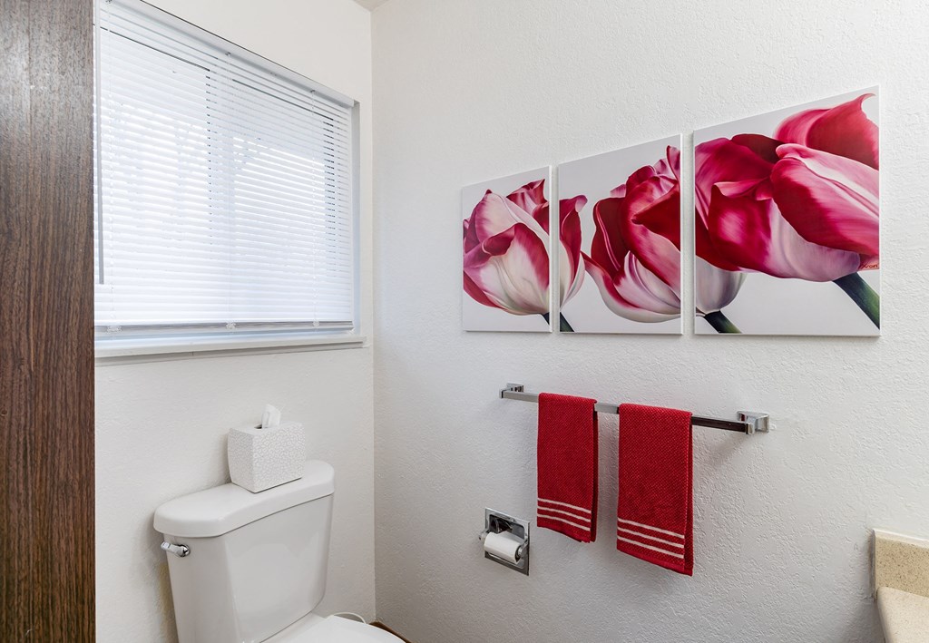 a bathroom with three pink flowers on the wall  at Pheasant Run, Michigan