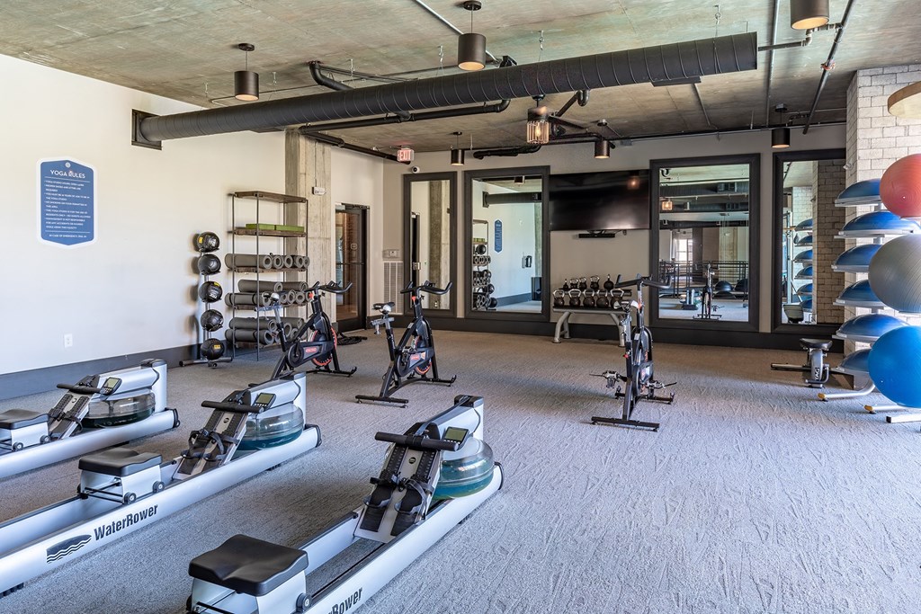 a gym with treadmills and other exercise equipment in a building with glass doors