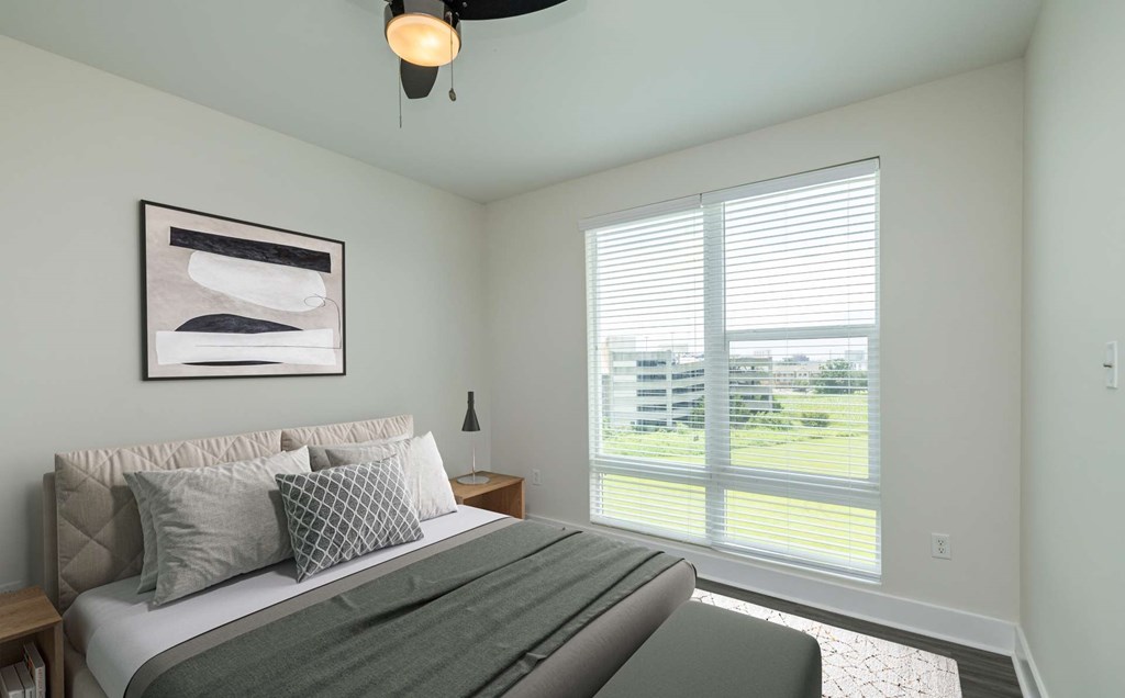 A bedroom with a large bed and a ceiling fan.