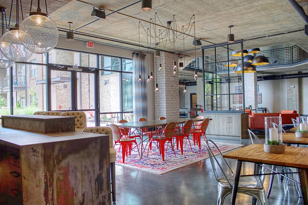 a dining room with red chairs and a table in a loft