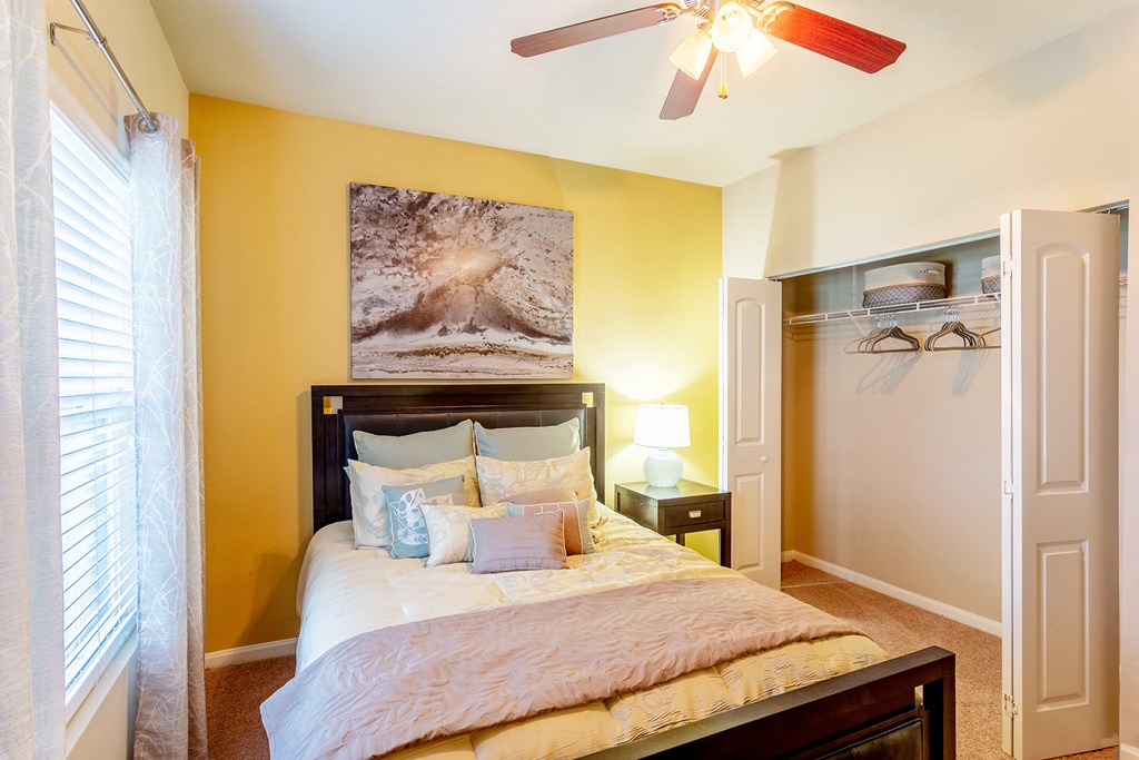 a bedroom with a large bed and a ceiling fan