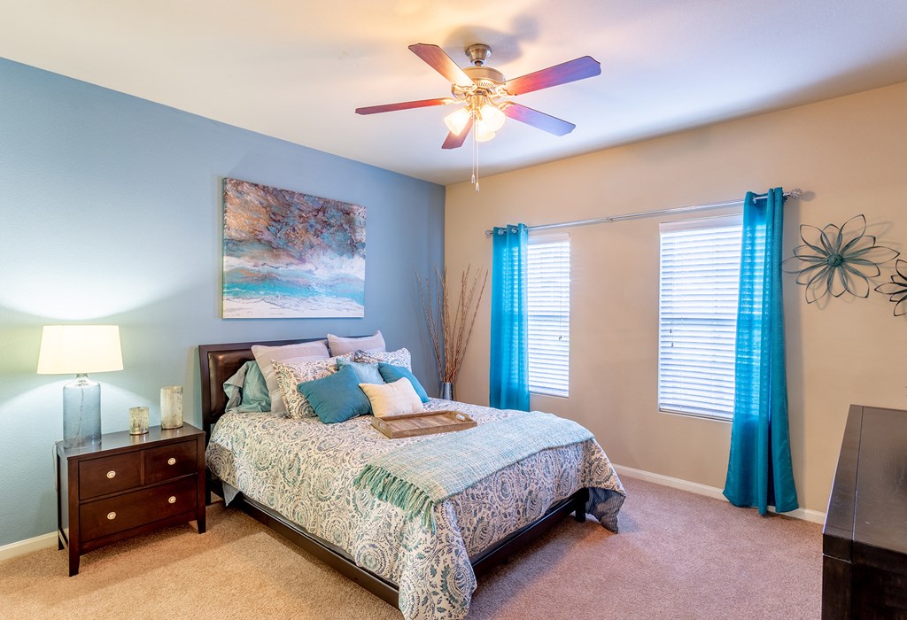 a bedroom with a bed and a ceiling fan