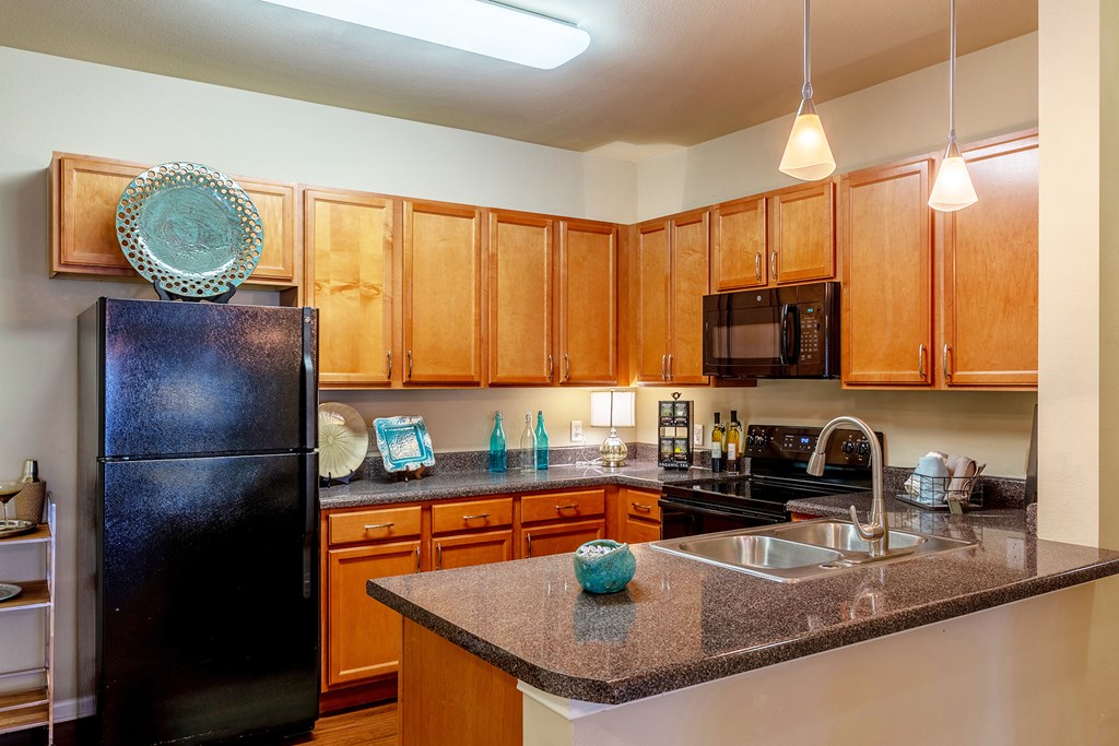 a kitchen with black appliances and granite counter tops