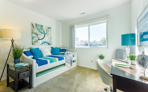 a bedroom with a bed and a desk with a chair