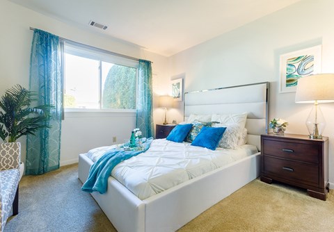 a bedroom with a white bed and blue pillows