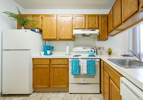a kitchen with white appliances and wooden cabinets