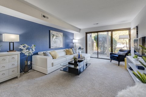 a living room with a blue accent wall and a white couch