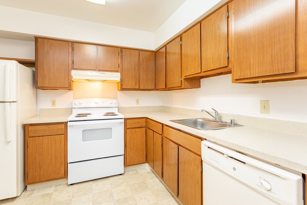 a kitchen with white appliances and wooden cabinets at Winchell Way Apartment , Michigan