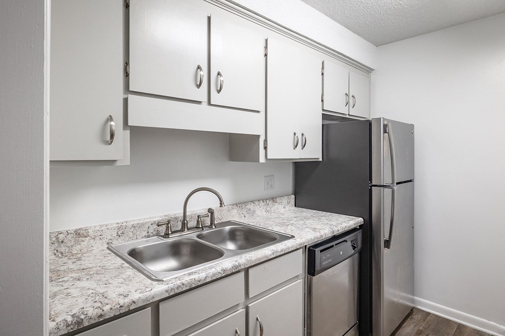 a kitchen with white cabinets and granite countertops
