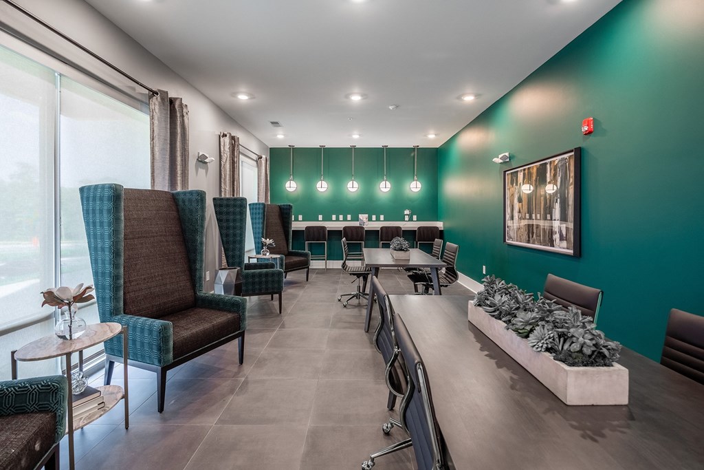 a restaurant with green walls and chairs and a bar with tables and chairs