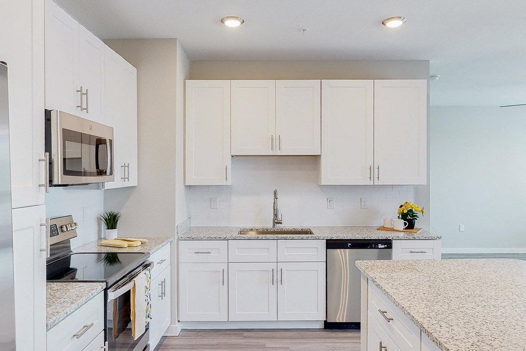 a kitchen with white cabinets and a counter top