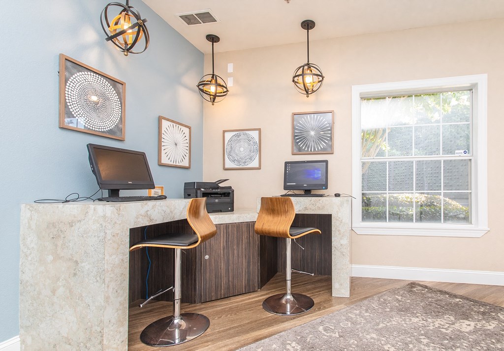 an office with two chairs and a desk with a window