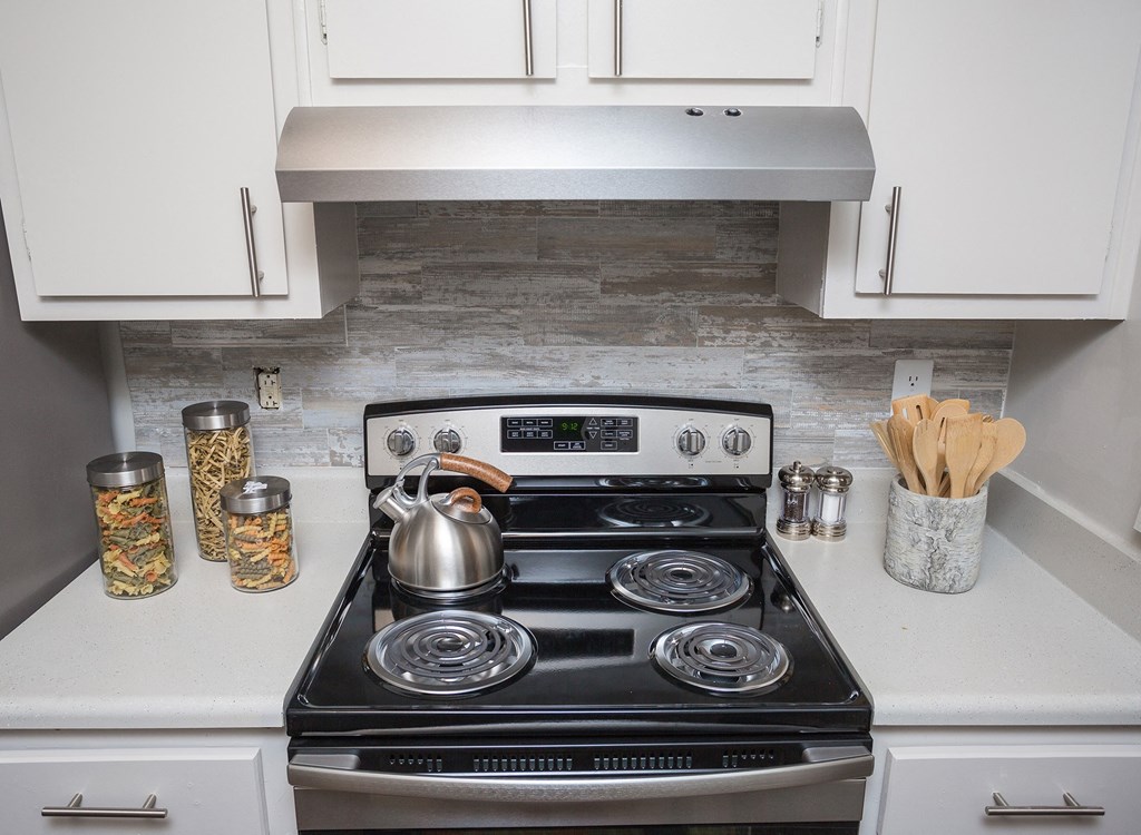 a small kitchen with a stove and a kettle on it