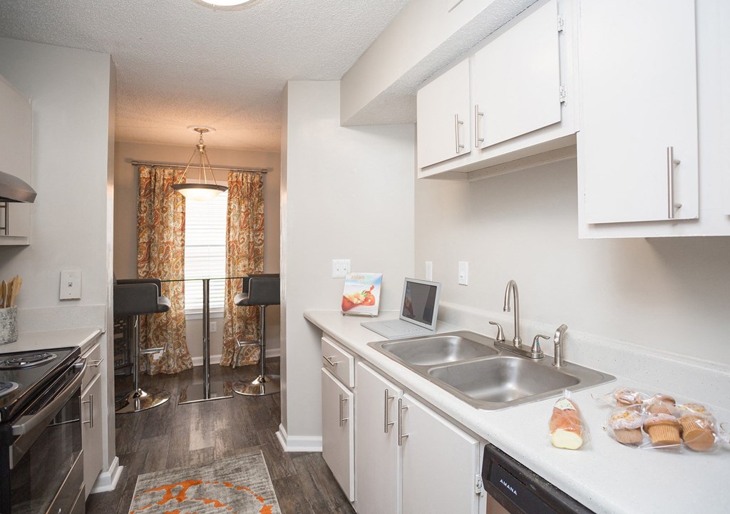 a kitchen with white cabinets and a stainless steel sink