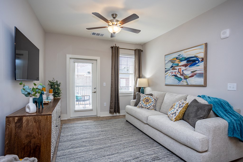 a living room with a couch and a ceiling fan
