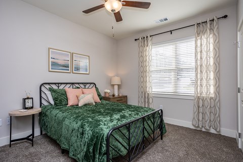 a bedroom with a bed and a ceiling fan