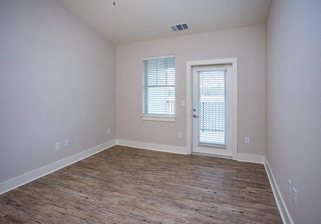 an empty room with a hard wood floor and white walls