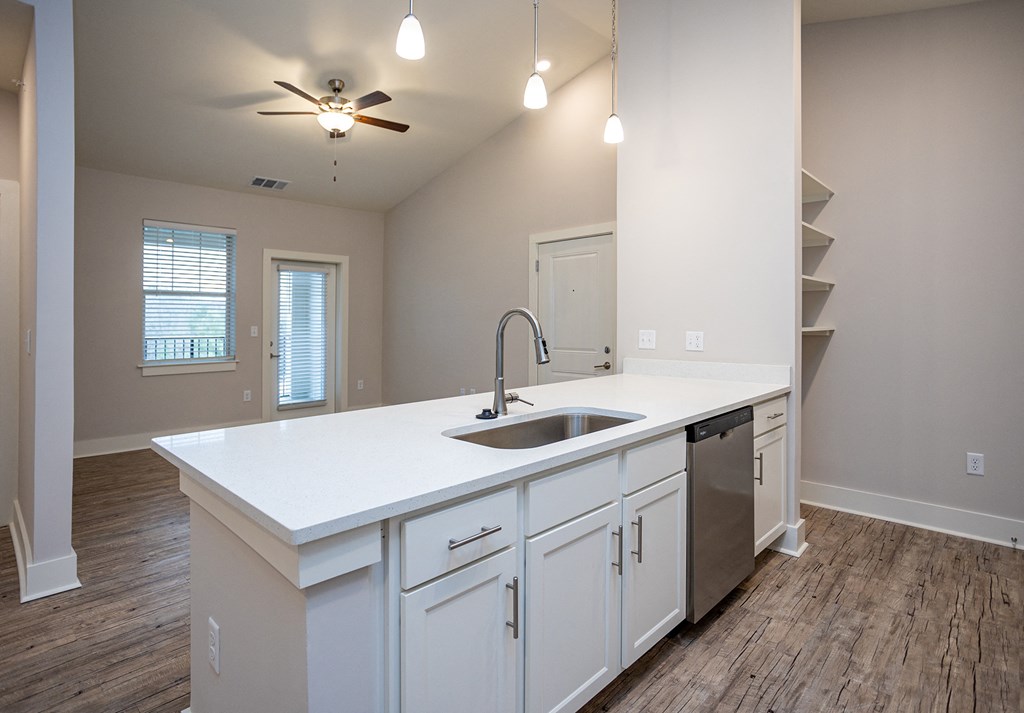 an empty kitchen with a large counter top and a sink