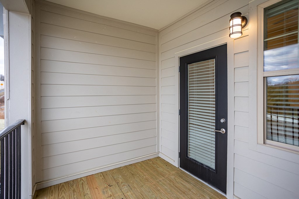 the living room of a house with white walls and a wooden floor