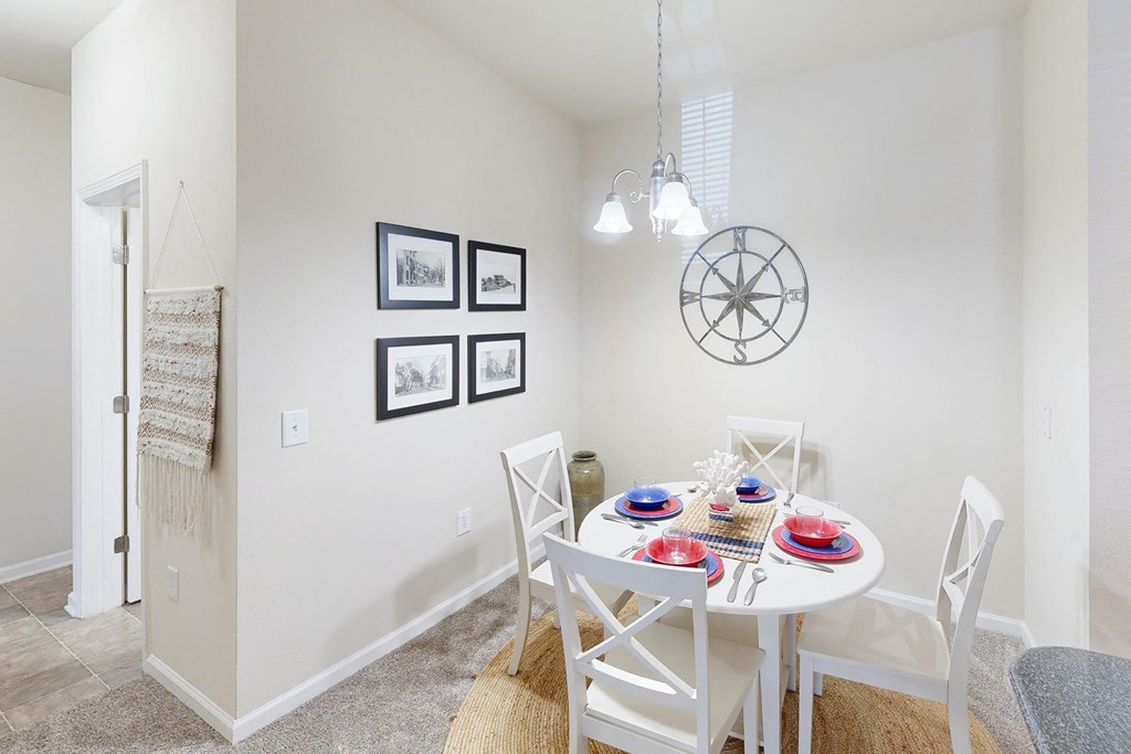 a dining room with a white table and chairs
