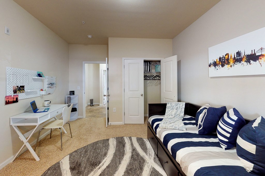 a bedroom with a bed and a desk and a closet