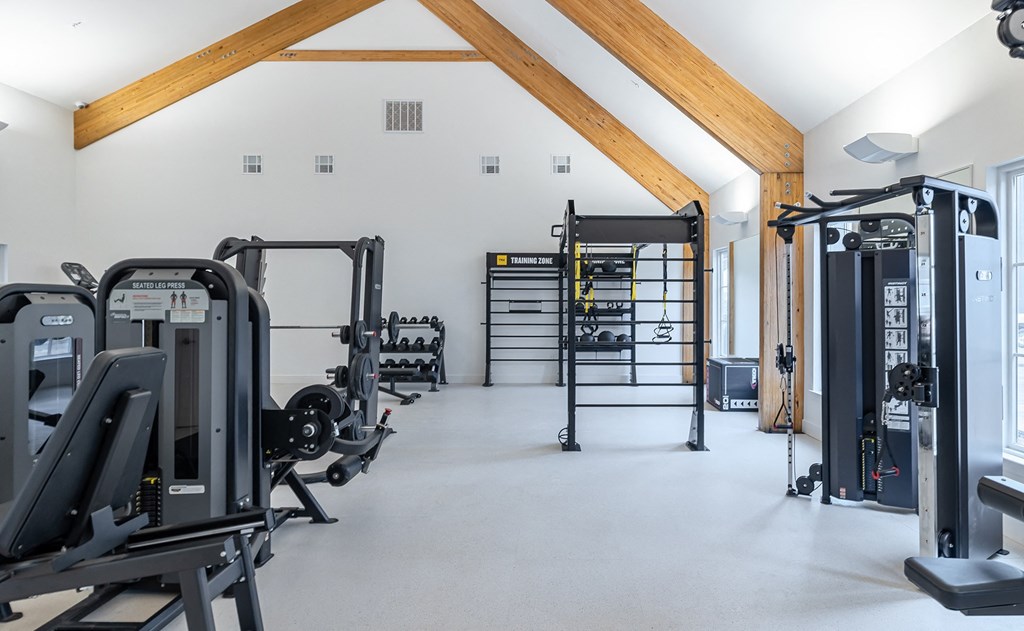 a gym with cardio equipment and weights on the floor
