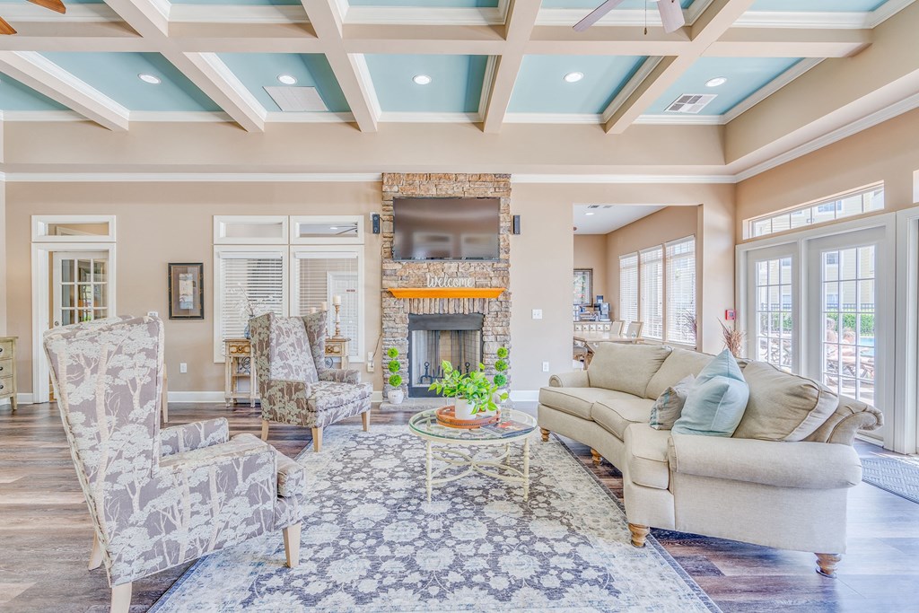 a living room with a coffered ceiling and a fireplace